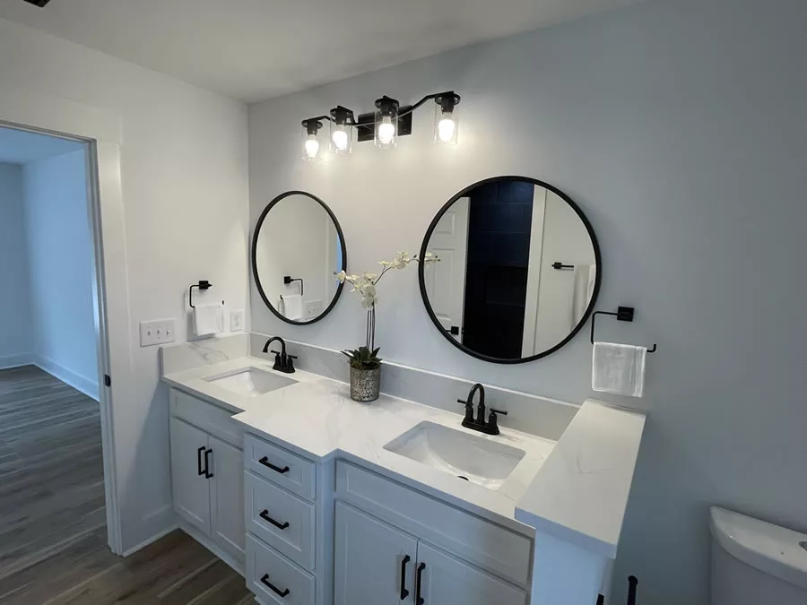 Bathroom remodeled with twin sinks and mirrors.