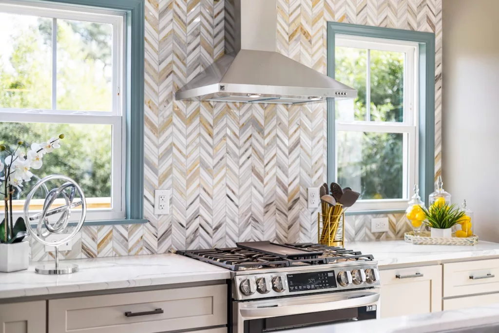 Earth tone backsplash behind a stove in a cozy kitchen.